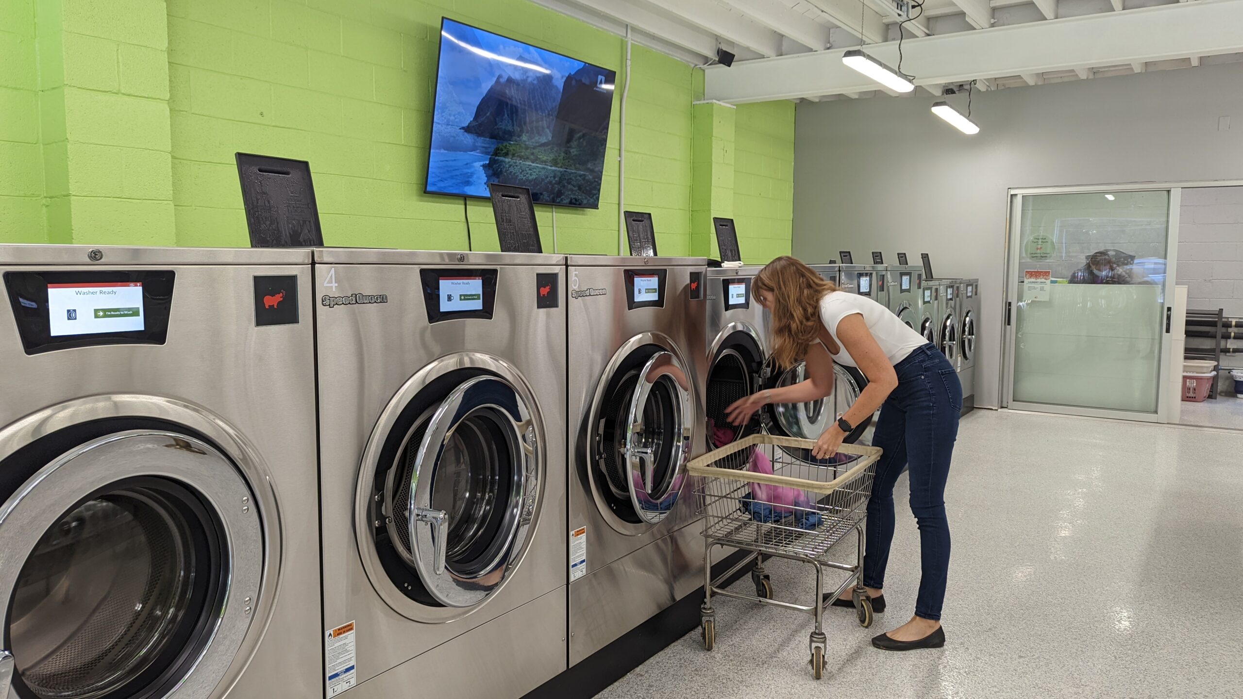 Woman putting clothes on laundromats
