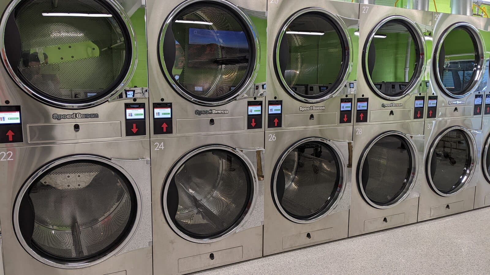 A row of Speed Queen stack tumbler dryers with their doors open