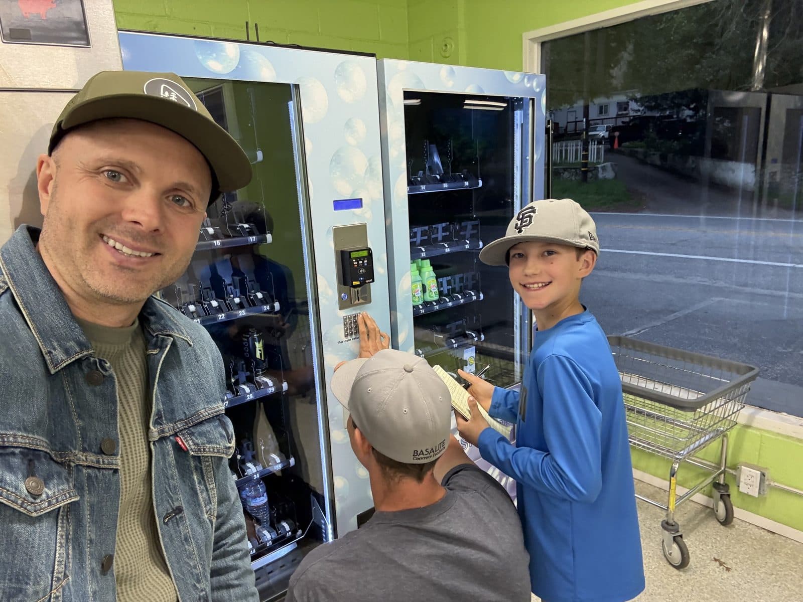 A family at the vending machines inside The Mat, buying detergent and a drink