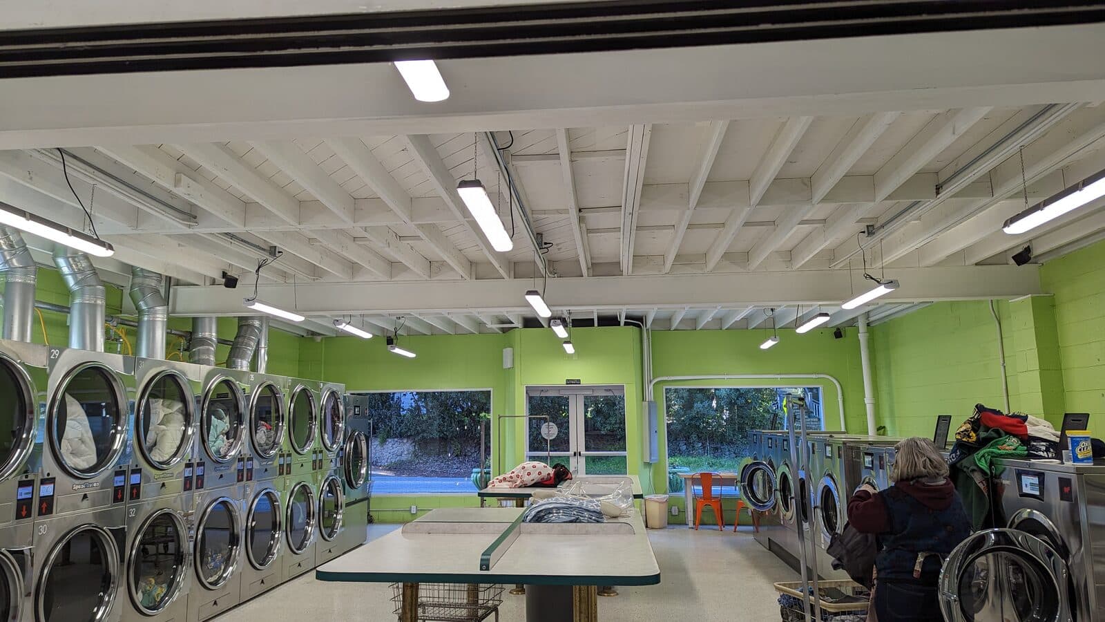 Inside The Mat, looking down the folding tables toward the front windows, with dryers along the left wall